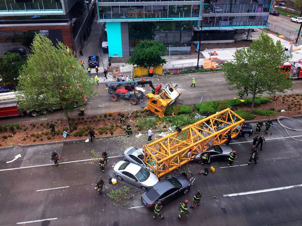 Fire and police crew members work to clear the scene where a construction crane fell from a building on Googles new Seattle campus crashing down onto one of the citys busiest streets and killing multiple people on Saturday. (AP Photo/Frank Kuin)