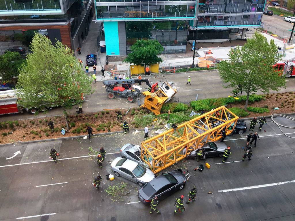 Fire and police crew members work to clear the scene where a construction crane fell from a building on Googles new Seattle campus crashing down onto one of the citys busiest streets and killing multiple people on Saturday. (AP Photo/Frank Kuin)