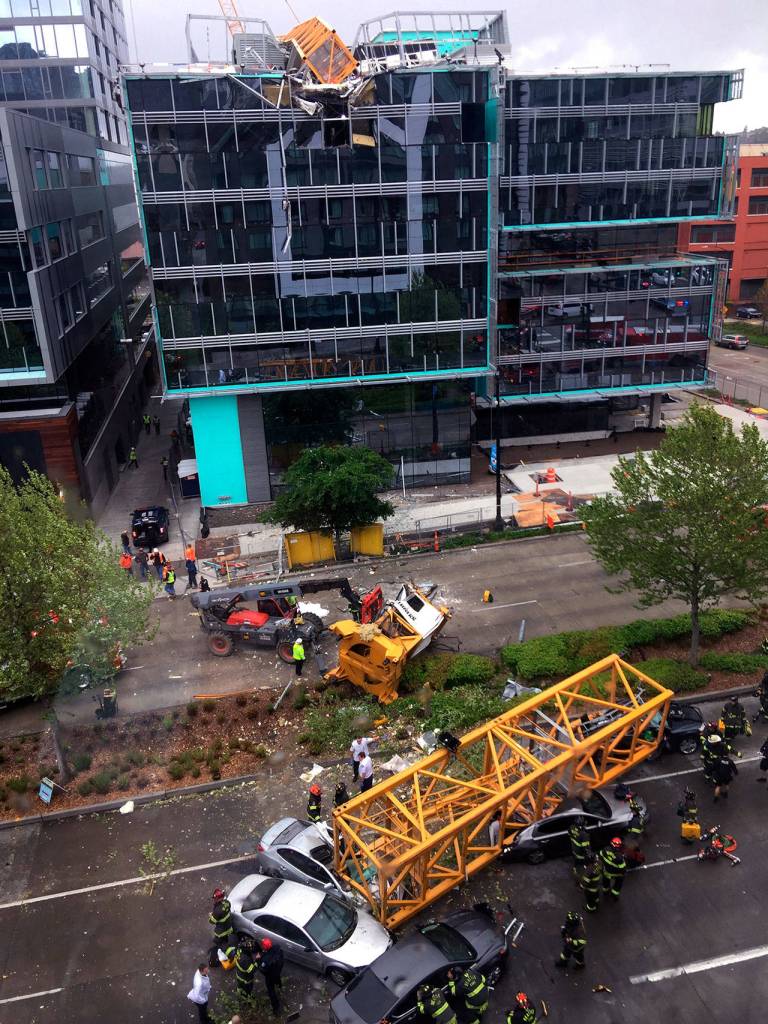 Fire and police crew members work to clear the scene where a construction crane fell from a building on Googles new Seattle campus crashing down onto one of the citys busiest streets and killing four people on Saturday. (AP Photo/Frank Kuin)