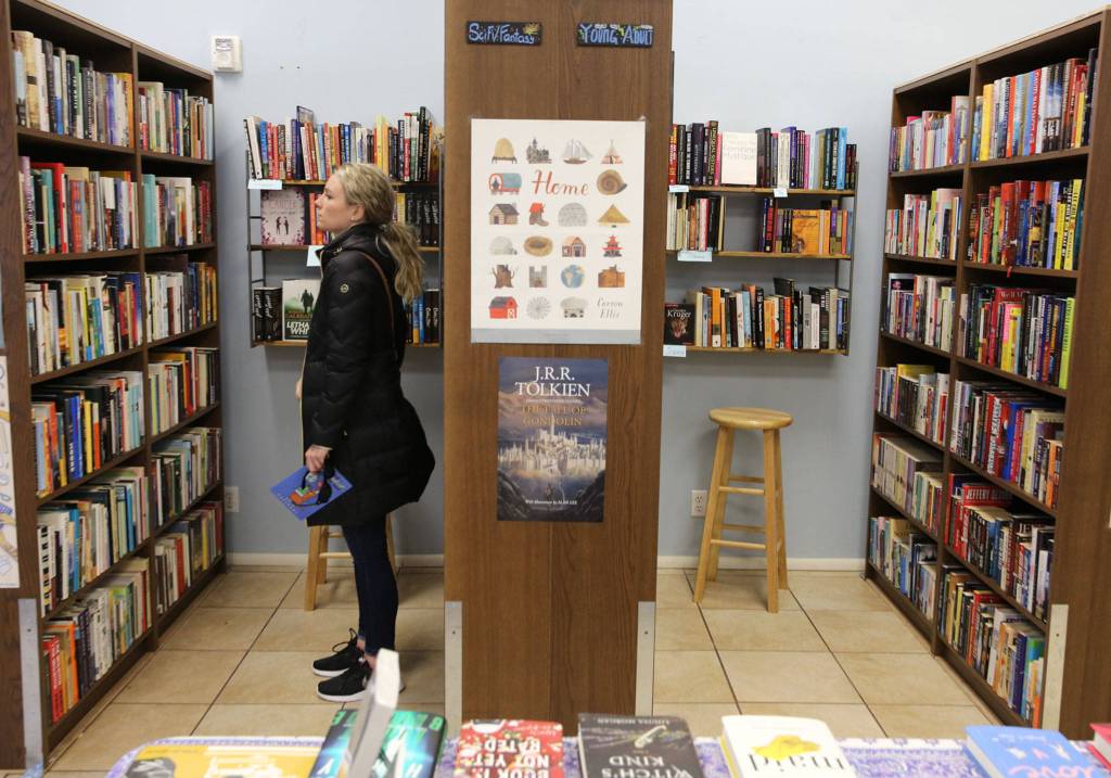 Lauren Hope browses the shelves of Neverending Bookstore in Edmonds. People who visited 21 stores earned a 25-percent discount for the entire year. (Kevin Clark / The Herald)