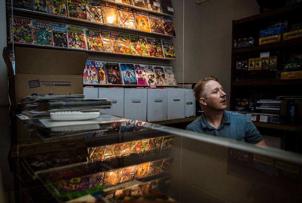 Russ Bright talks with employee Jon Bell as they stock peoples subscriptions at Mill Geek Comics on May 1 in Bothell. (Olivia Vanni / The Herald)