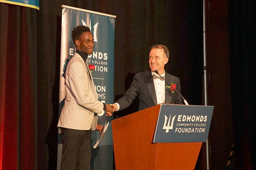 Kevin Joyce (right), emcee for the Edmonds Community College Foundations awards gala, presents student Mustapha Samateh the Student Spotlight. Samateh shared his story of overcoming adversity when he came to the U.S. as a student seeking political asylum from The Gambia. (Edmonds Community College)