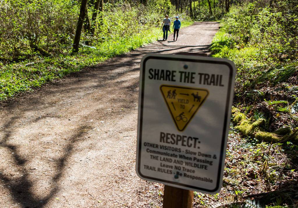 A sign reminding park goers to share the trail along the Main Trail at Lord Hill Regional Park on April 4 in Snohomish. (Olivia Vanni / The Herald)