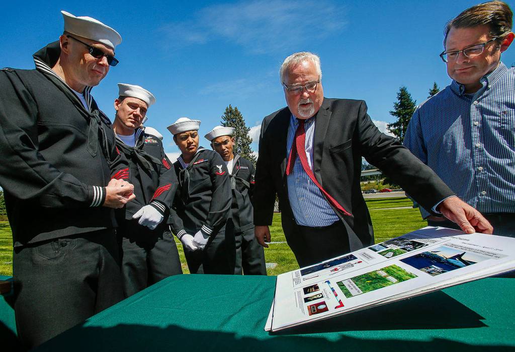 At Cypress Lawn Memorial Park, Dan Hoeglund, of Lake Stevens, shows a display that tells the story of his great uncle, Daniel Guisinger Jr. (Dan Bates / The Herald)