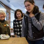 Judy Kusakabe smiles as students look at her artifacts and internment camp materials after her talk at Kamiak High School. (Olivia Vanni / The Herald)