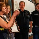 Assistance League of Everett s Caryl de Jong (left) and Rock Dorsey present the National Operation School Bell award to North County Fire/EMS Lt. Gary Lingel and Gabe Buonassissi Thursday at Everett Golf and Country Club. (Dan Bates / The Herald)