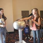 Cozette Vallerie (right) experiments with a Van De Graff provided by Imagine Childrens Museum. (Submitted photo)
