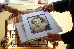 In the north Everett home where she and her sister Margaret Mugsy Duryee grew up, Maureen Duryee sorts through photographs of their mother Mary Duryee. This portrait was Marys Everett High School 1935 graduation portrait. She died April 22 at age 100. (Dan Bates / The Herald)