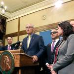Gov. Jay Inslee, surrounded by Democratic lawmakers from the Senate and House, talks to the media following the Washington Legislature adjourning its 105-day legislative session Monday in Olympia. (AP Photo/Rachel La Corte)