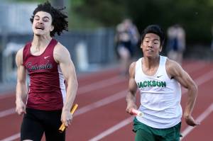 Cascades Michael Purl (left) edges out Jacksons Koji Asuncion in the 4x100 Meter relay Friday afternoon during the Everett City Championships at Everett Memorial Stadium on May 3, 2019. (Kevin Clark / The Herald)