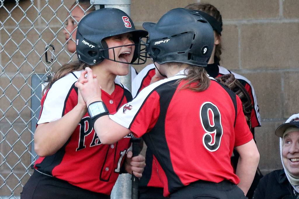 Snohomishs Anna Robinson (left) celebrates with Kayla Flores after Flores scores a run at Lincoln Field in Everett on May 1. (Kevin Clark / The Herald)