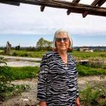 Dianna Biringer loves the open space and mountain views she has enjoyed while living on Spencer Island for nearly 35 years. In the background to her right is the old farmhouse where she and her husband Mike have made their home. (Dan Bates / The Herald)