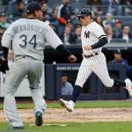 New Yorks Mike Tauchman scores on DJ LeMahieus second-inning single as Seattle Mariners starting pitcher Felix Hernandez looks on during Monday nights game in New York. (AP Photo/Kathy Willens)