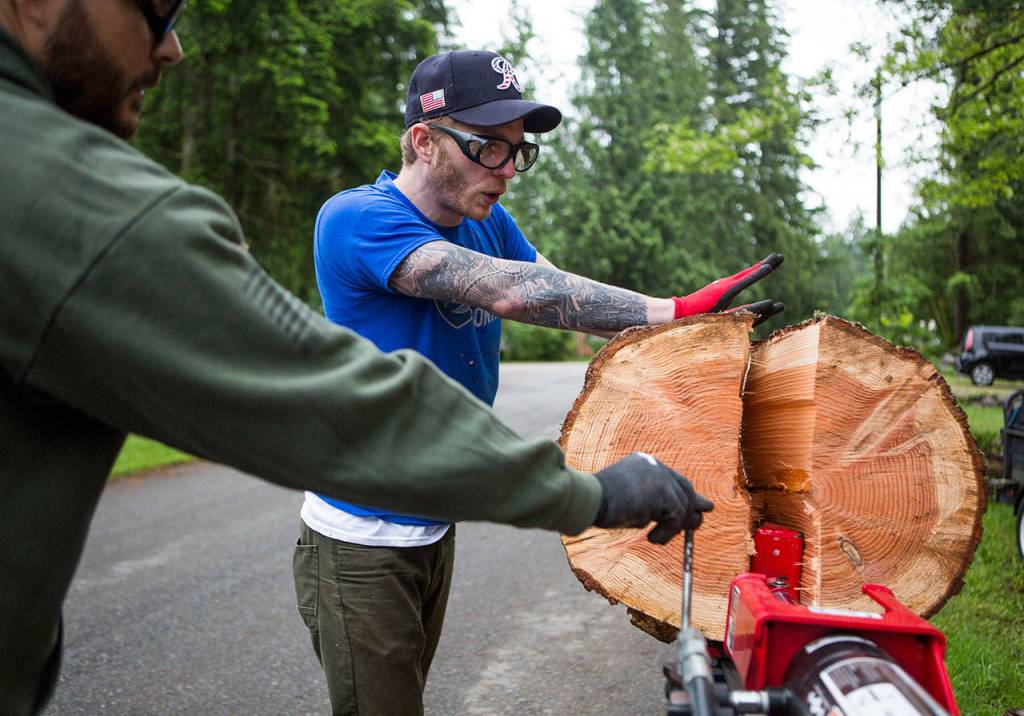 Wes King, an Army veteran, helps split wood during a Habitat for Humanity build on Saturday in Gold Bar. (Olivia Vanni / The Herald)
