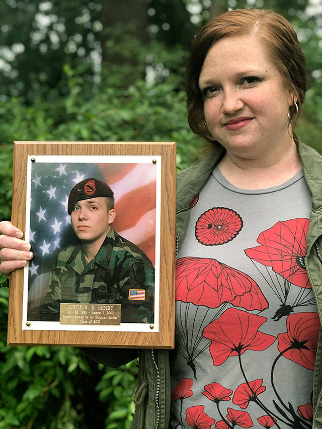 Jessica Hebert holds a photo of her brother, Army Spc. Justin Hebert, who was killed in combat in Iraq at age 20 in 2003. Hebert, of Everett, spoke at the luncheon for volunteers at a Habitat for Humanity Veterans Build event in Gold Bar. (Andrea Brown / The Herald)