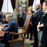 Washington Gov. Jay Inslee signs Senate Bill 5205 into law Tuesday as supporters look on at the Capitol in Olympia. (AP Photo/Ted S. Warren)