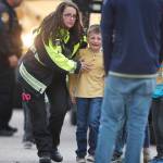 Officials guide students off a bus and into a recreation center where they were reunited with their parents after a shooting at a suburban Denver middle school Tuesday in Highlands Ranch, Colorado. (AP Photo/David Zalubowski)