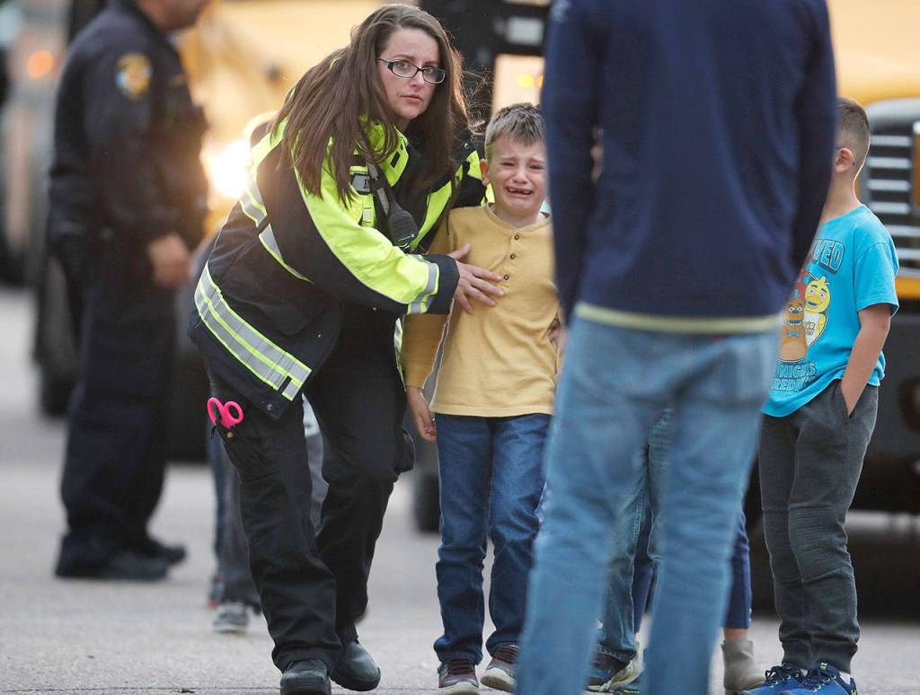 Officials guide students off a bus and into a recreation center where they were reunited with their parents after a shooting at a suburban Denver middle school Tuesday in Highlands Ranch, Colorado. (AP Photo/David Zalubowski)