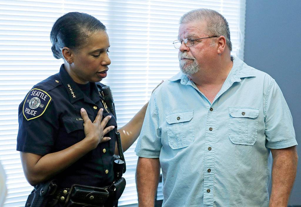 Seattle Police Chief Carmen Best (left) talks with Chris Galvin on Tuesday in Seattle after police said they have solved the 1967 murder of his sister, Susan Galvin. (AP Photo/Ted S. Warren)