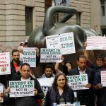 Uber drivers protest next to the Charging Bull statue in New Yorks financial district Wednesday. (AP Photo/Mark Lennihan)