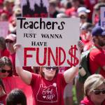 Thousands of Oregon teachers and education supporters march Wednesday in Portland. Tens of thousands of teachers across Oregon walked off the job Wednesday to demand more money for schools, holding signs and wearing red shirts that have become synonymous with a nationwide movement pushing lawmakers to better fund education. (Beth Nakamura/The Oregonian via AP)