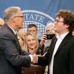 Gov. Jay Inslee shakes hands with Joshua Stuller after deeming him Washingtonian of the Day following the signing of a bill that seeks to speed up competency evaluations for defendants at jails, on Thursday in Olympia. Stuller, who advocated for the legislation, was released from Eastern State Hospital last year. (AP Photo/Rachel La Corte)