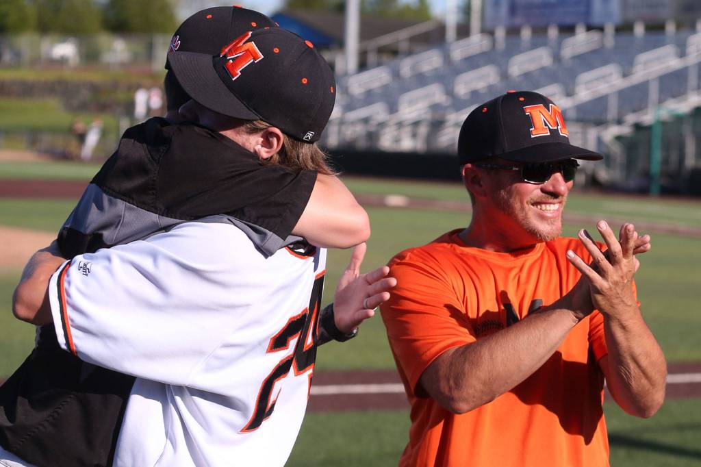 Ninth-year Monroe coach Eric Chartrand (right) celebrates after his teams state-clinching victory. (Kevin Clark / The Herald)