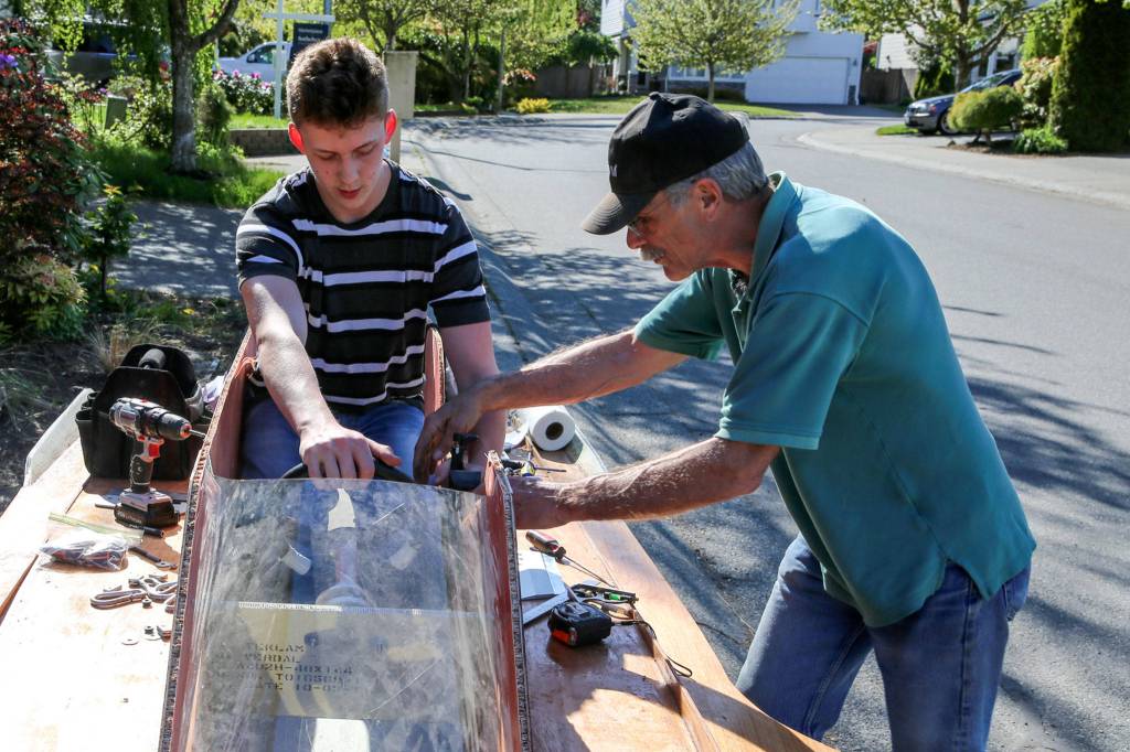 Peter Olesen (left) and Jim Tryon work to configure the throttle Wednesday afternoon. (Kevin Clark / The Herald)
