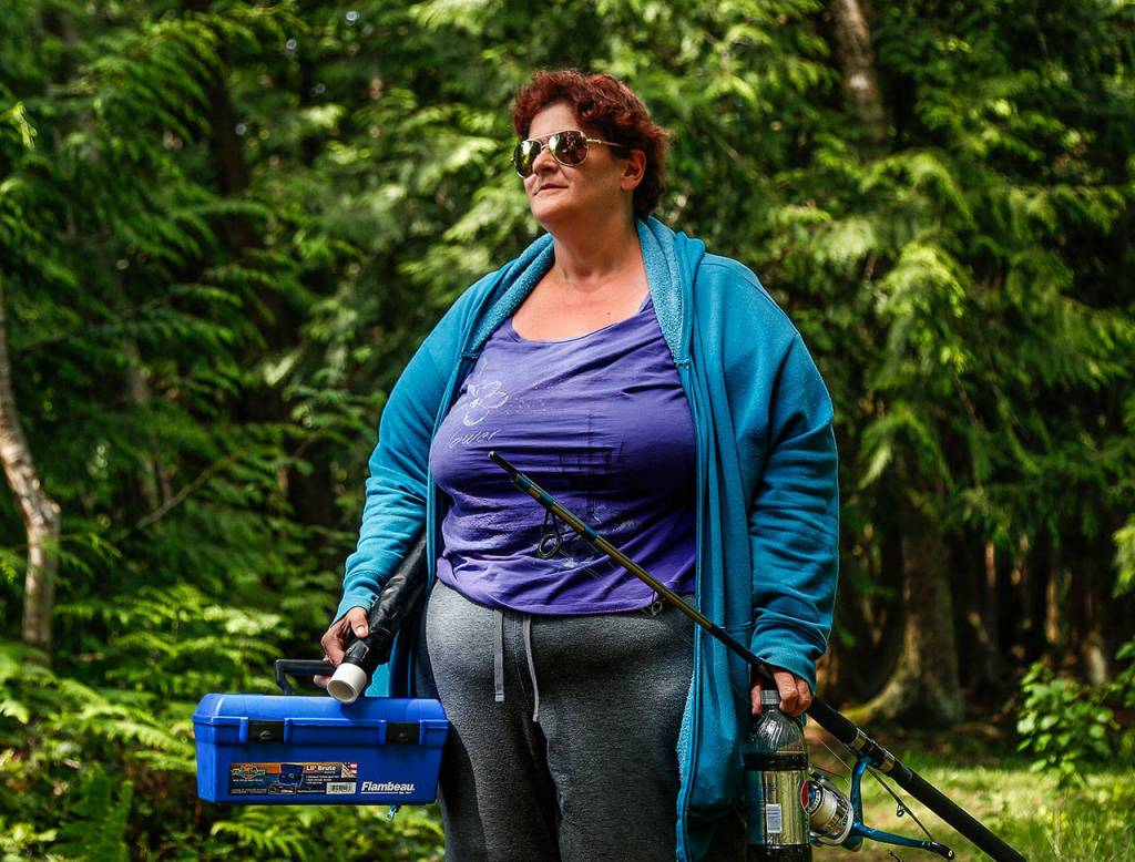 Melissa Gisvold, 42, of Stanwood, takes a break from fishing at Gissberg Twin Lakes Wednesday. (Dan Bates / The Herald)
