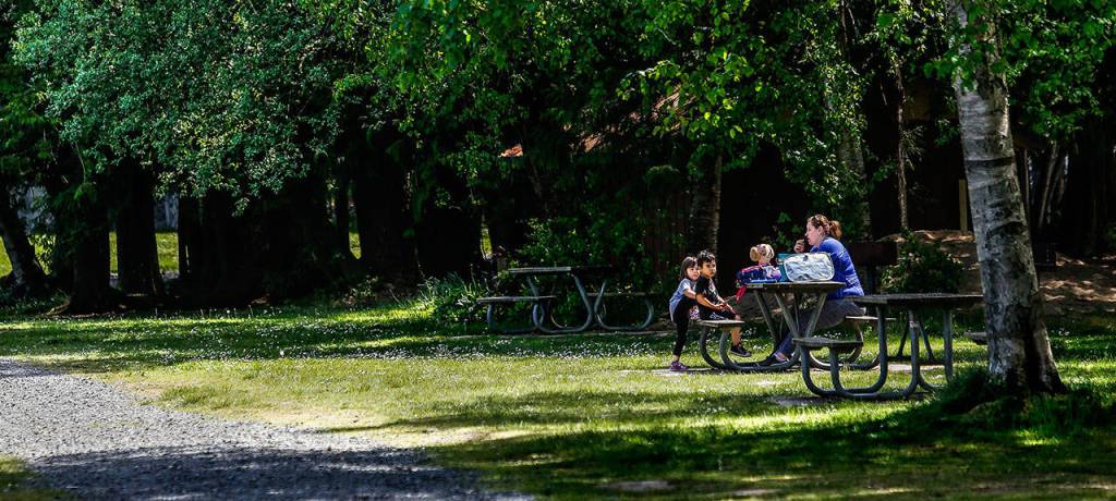 Svetlana Pisarenko, 38, enjoys bringing her preschool-age children 3-year-old Camilla (left), and Alesha 4, for a picnic lunch at the North Lake of Gissberg Twin Lakes county park Wednesday while her two older children are in school. (Dan Bates / The Herald)