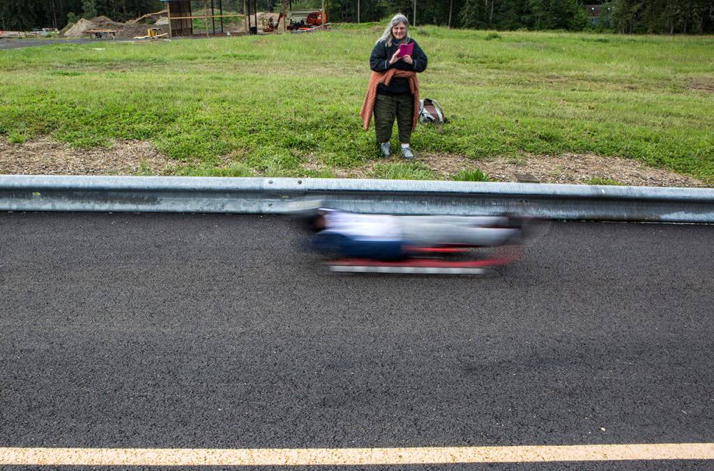 A parent takes a video as one of the lugers takes a practice run down the track during the USA Luge Slider Search program Sunday at Arrowhead Ranch on Camano Island. (Olivia Vanni / The Herald)