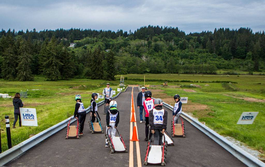 Participants walk onto the track during the USA Luge Slider Search program Sunday at Arrowhead Ranch on Camano Island. (Olivia Vanni / The Herald)