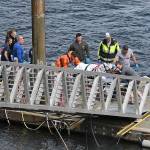 Emergency response crews transport an injured passenger to an ambulance at the George Inlet Lodge docks Monday in Ketchikan, Alaska. The passenger was from one of two float planes reported down in George Inlet early Monday afternoon and was dropped off by a U.S. Coast Guard 45-foot response boat. (Dustin Safranek/Ketchikan Daily News via AP)