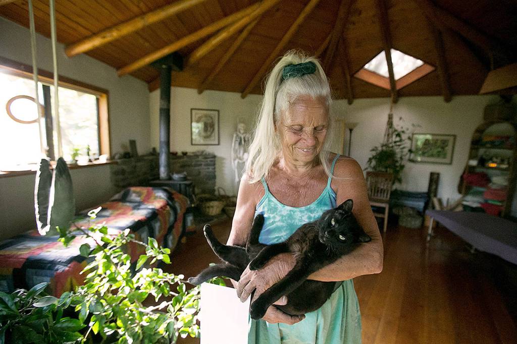 Lynn Cosmos holds her black cat Silly inside her Yakima home studio May 13. (Amanda Ray / Yakima Herald-Republic)