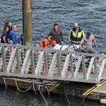 Emergency response crews transport an injured passenger to an ambulance Monday at the George Inlet Lodge docks, in Ketchikan, Alaska. The passenger was from one of two sightseeing planes reported down in George Inlet early Monday afternoon and was dropped off by a U.S. Coast Guard 45-foot response boat. (Dustin Safranek/Ketchikan Daily News via AP)