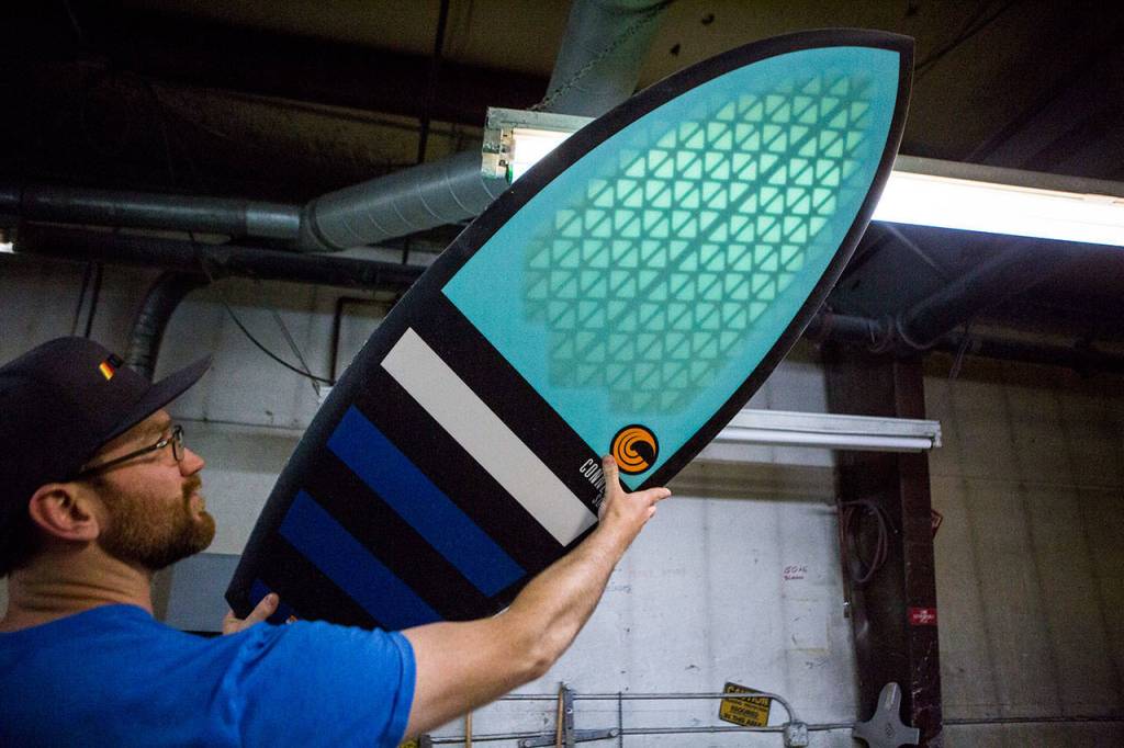 Connelly Skis marketing manager Collin Spradlin reveals the structure that helps make a board lighter. (Olivia Vanni / The Herald)
