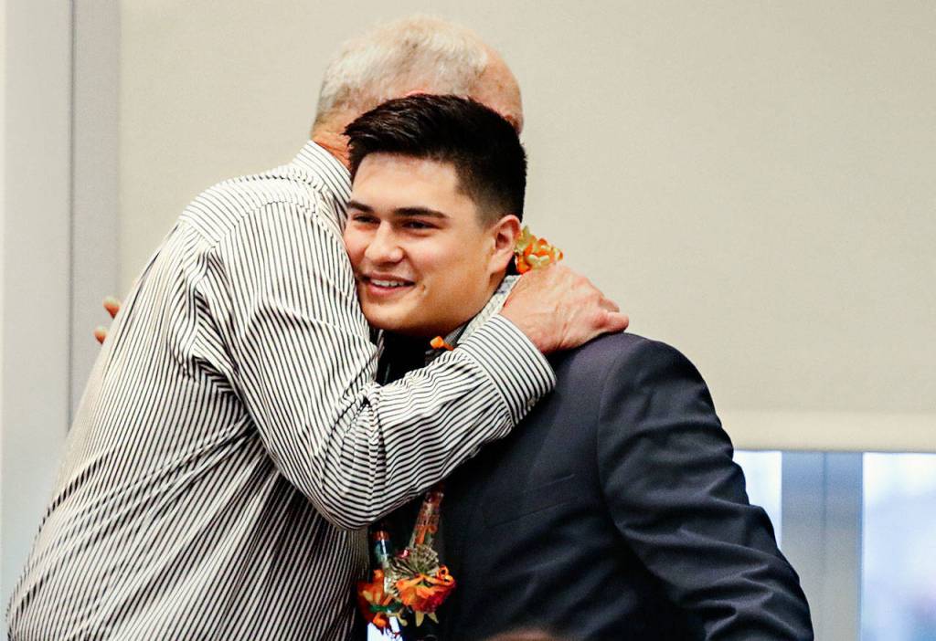 Following the presentation of the Brett Akio Jensen Scholarship, Joseph Hofman receives a hug from Bretts father, Don Jensen. Hofman will attend Georgetown University. (Dan Bates / The Herald)
