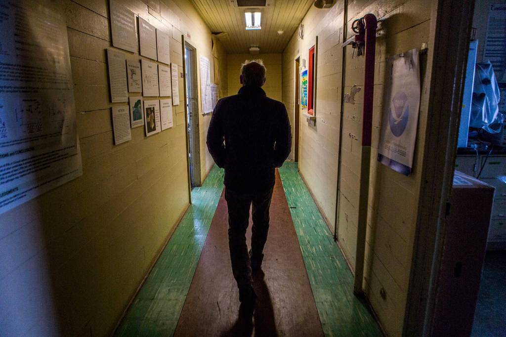 Paul McElhany, Mukilteo Station chief, walks down the uneven second floor hallway at Northwest Fisheries Science Centers Mukilteo Research Station on April 23. (Olivia Vanni / The Herald)