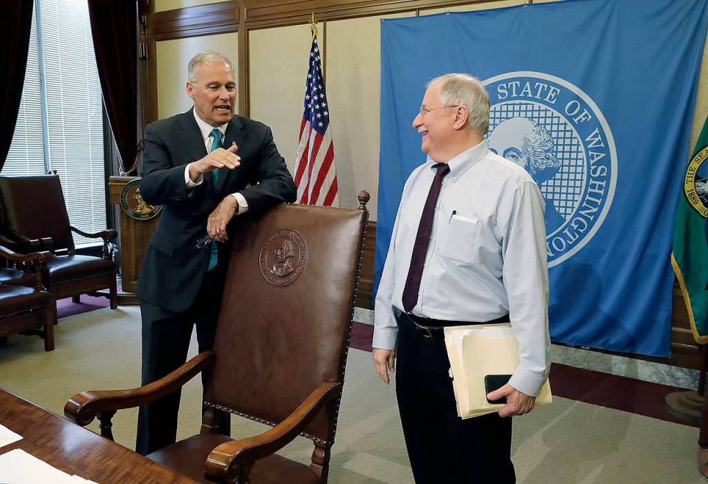 Washington Gov. Jay Inslee (left) talks with House Speaker Frank Chopp, D-Seattle (right), after Inslee signed the state operating budget Tuesday. (AP Photo/Ted S. Warren)