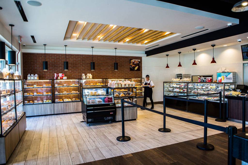 A worker yells out Fresh bread! as she brings out a tray of freshly baked goods at 85°C Bakery Cafe in Edmonds. (Olivia Vanni / The Herald)