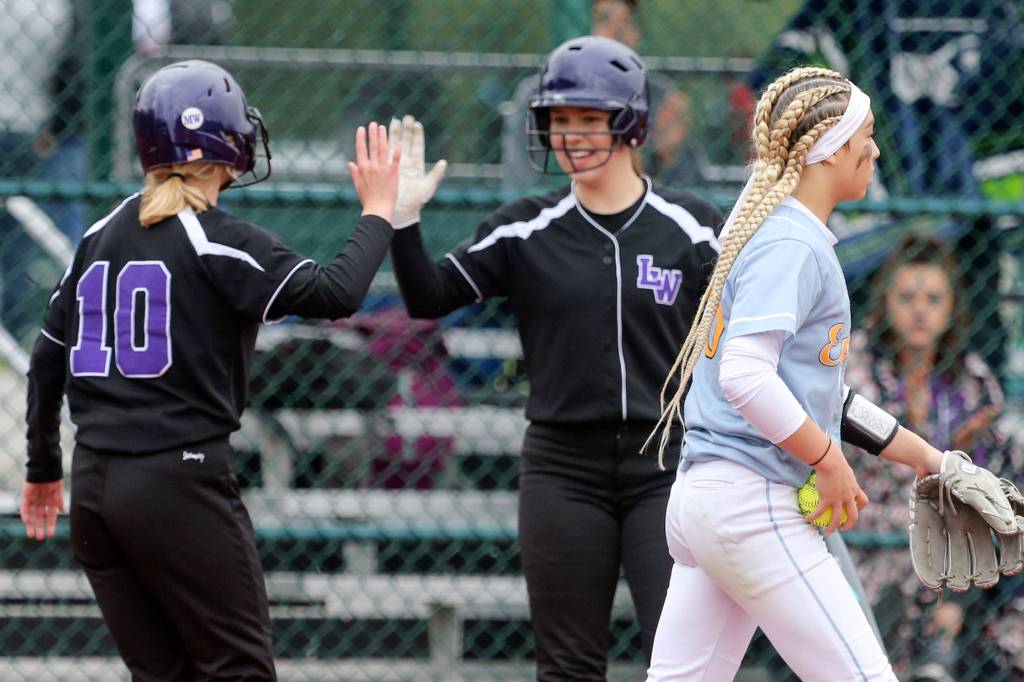 Lake Washington celebrates a run off of Everetts Jackie Rookaird (right) Friday morning during the 3A Softball State Championship at the Regional Athletic Complex in Lacey. (Kevin Clark / The Herald)