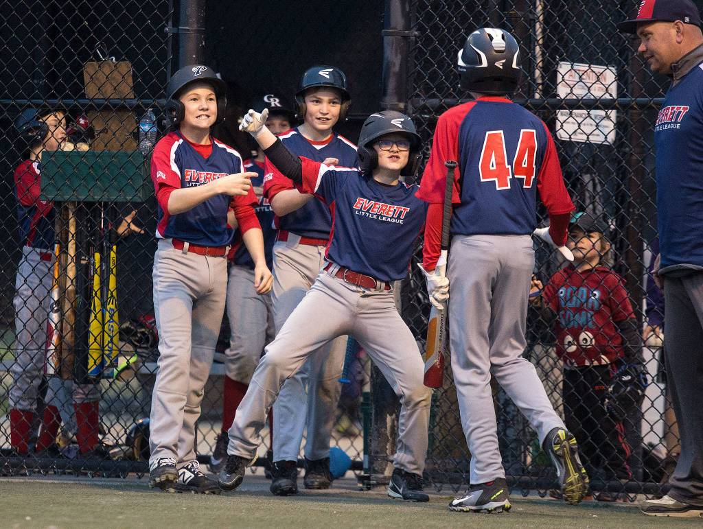 Players come out of the dugout to congratulate Donovan MacDonald (44) after scoring a run for the Gaffney Construction Little League team at Phil Johnson Ballfields on April 25 in Everett. (Andy Bronson / The Herald)
