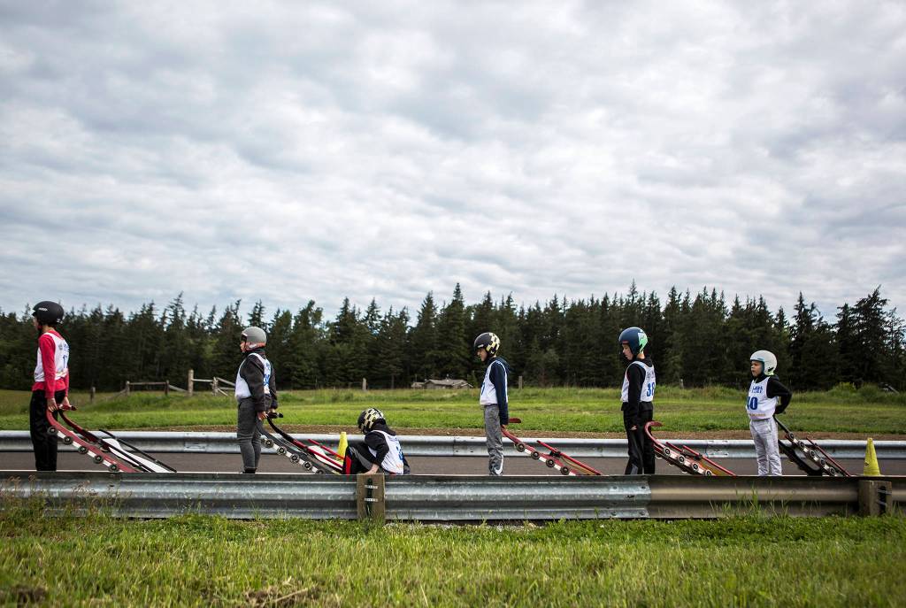 Participants line up for a practice luge run down during the USA Luge Silder Search program at Arrowhead Ranch on May 19 in Camano Island. (Olivia Vanni / The Herald)