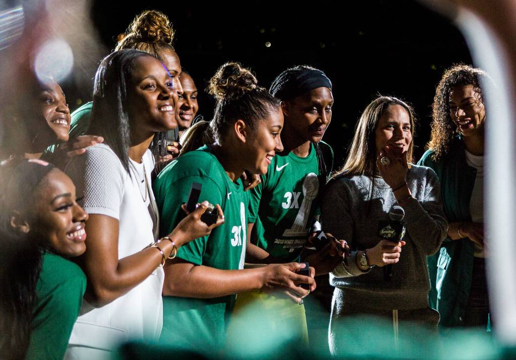 The Seattle Storm show off their championship rings for the television cameras after the ring ceremony before the season opener game against the Phoenix Mercury on Saturday, May 25, 2019 in Everett, Wash. (Olivia Vanni / The Herald)