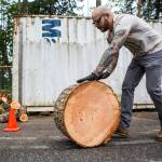 Dustin Comey, a veteran who served in the Marines from 2003 to 2007, helps moves logs during the Habitat for Humanity veteran home build on May 25 in Gold Bar. (Olivia Vanni / The Herald)
