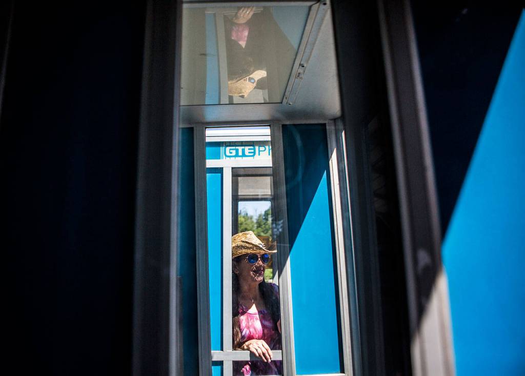 Store owner Cynthia Marie in one of her phone booths for sale. (Olivia Vanni / The Herald)