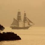 The tall ship Lady Washington sails off Port Orchard, in August 2018, through the smoky haze at sunset. The smoke was from the many wildfires in the Pacific Northwest and Canada. (Larry Steagall/Associated Press file photo)