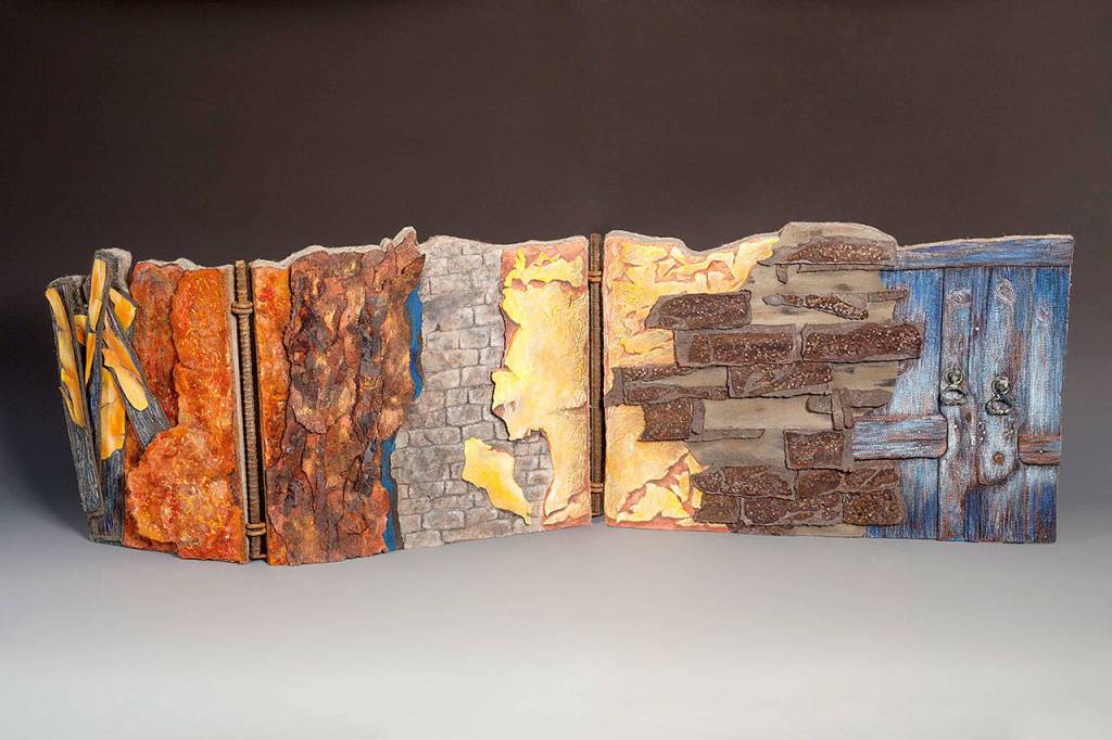 Terri Shinns Time Crumbles Things was inspired by photos of structural decay. She made an 18-inch-tall and 56-inch-long wall of fabric, felt, car-headliner padding, threads, texture mediums, plywood, rebar, hinges and door knockers.