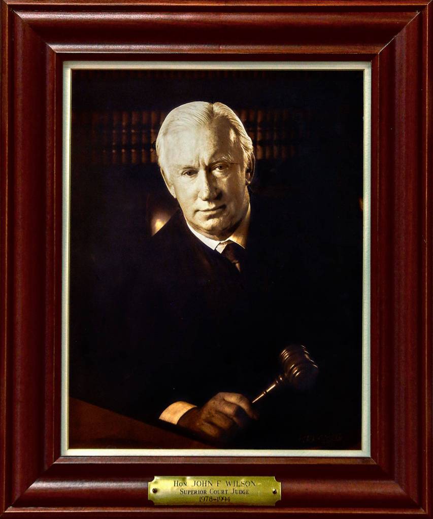 A photograph of Superior Court Judge John Wilson, who served 1978-1994, hangs with portraits of other judges at the Snohomish County Courthouse. His son, Judge Joe Wilson, is now on the bench. (Dan Bates / The Herald)