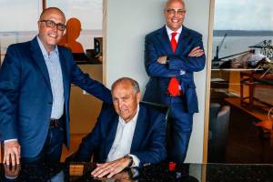 Now retired, Arthur Skodal (center) pays a visit to his sons, who now head Skotdal Real Estate. With him, in their glassy 12th-floor headquarters in the Key Bank Tower, are Craig Skodal (left) and Andy Skodal. (Dan Bates / The Herald)